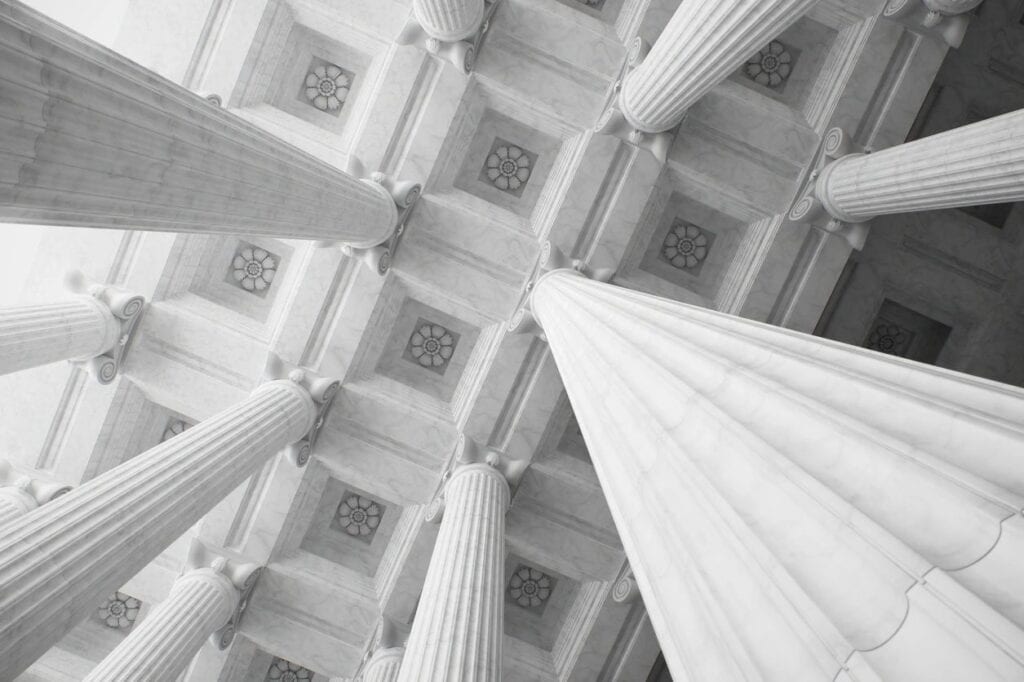Looking up at classical marble columns and ceiling